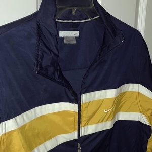 NWOT! Men’ medium Nike Jacket. Navy w/ white and gold stripes. Side zip pockets